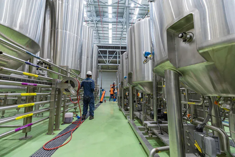 Tecnico de mantenimiento en planta lactea revisando una linea de proceso