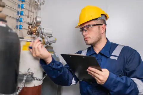 Técnico de mantenimiento relevando equipos y válvulas de proceso con una planilla en planta