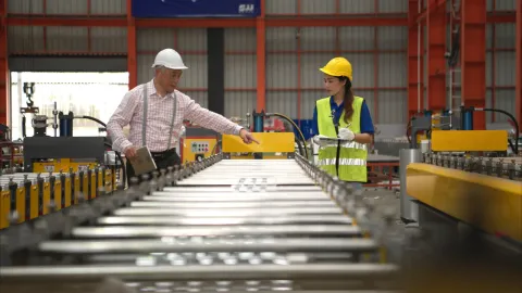 Ingenieros inspeccionando una línea de producción industrial para verificar trazabilidad técnica