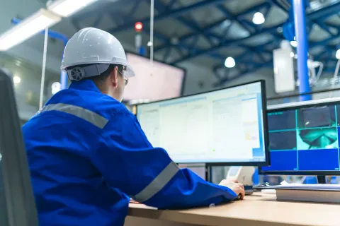 Supervisor monitoreando activos industriales desde la sala de control