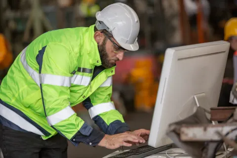 Técnico de mantenimiento revisando una solicitud desde el celular en planta