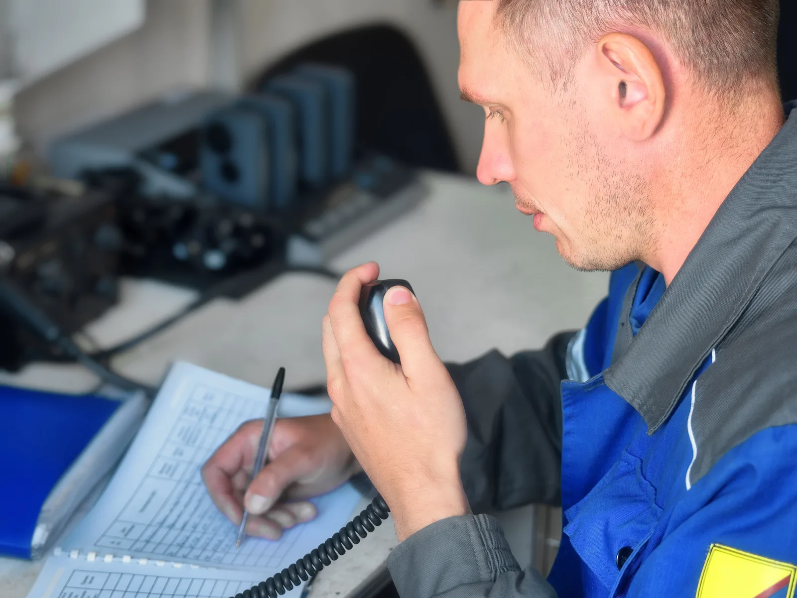 Técnico anotando en un cuaderno un aviso de mantenimiento recibido por radio